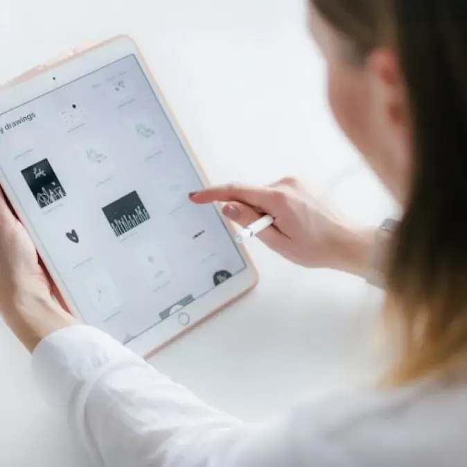 Une femme utilise un iPad pour afficher un site web.